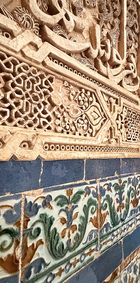 Carved plaster above painted tile
